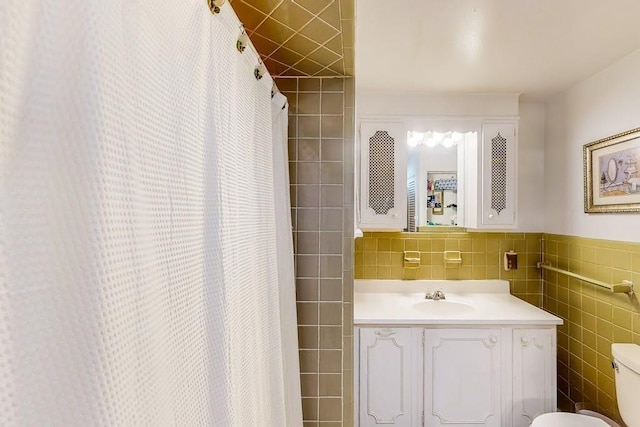 full bath featuring tile walls, toilet, vanity, and a shower with shower curtain