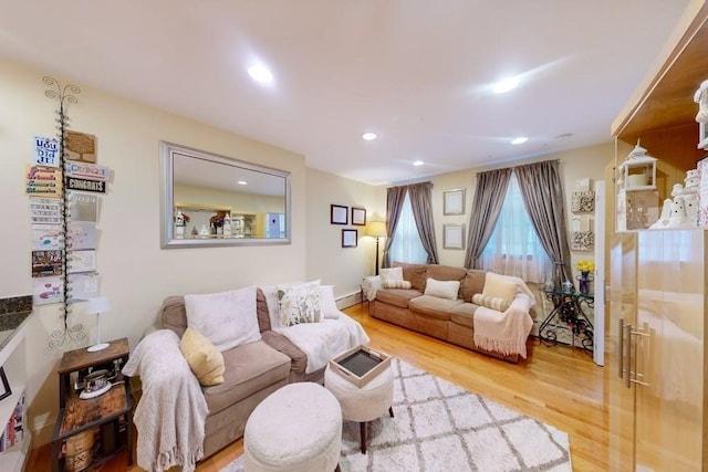 living area featuring wood finished floors, recessed lighting, and a baseboard radiator