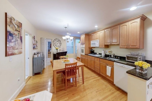 kitchen featuring white appliances, a sink, a chandelier, light wood-style floors, and recessed lighting