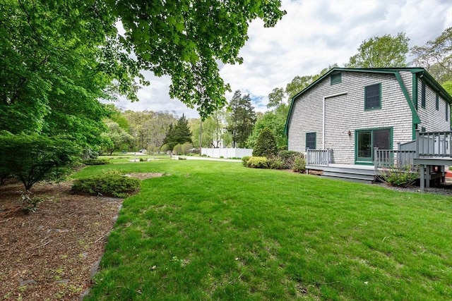 view of green lawn featuring a deck