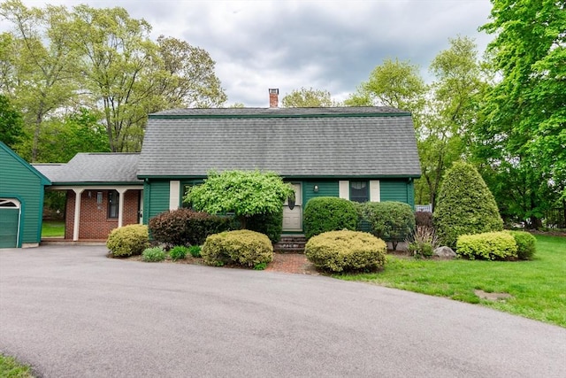 dutch colonial with a gambrel roof, a chimney, asphalt driveway, a shingled roof, and a garage