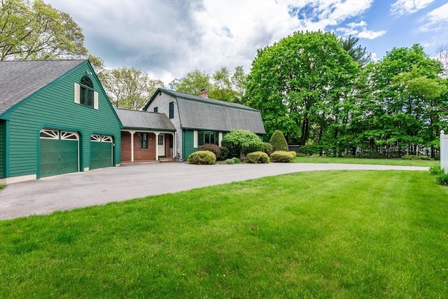 view of front of property with roof with shingles, driveway, a gambrel roof, and a front lawn