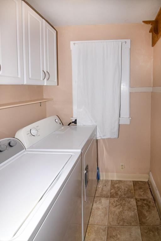 washroom with cabinets and washing machine and dryer