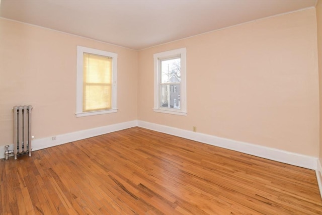 spare room featuring wood-type flooring and radiator