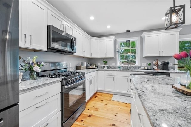 1085 Southbridge Rd, Warren, MA 01585 - kitchen featuring appliances with stainless steel finishes, recessed lighting, white cabinetry, light wood-style flooring, and decorative light fixtures