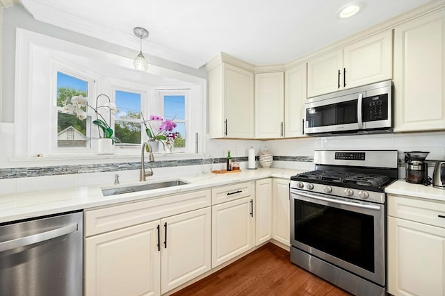 50 Depot St, Milford, MA 01757 - kitchen with appliances with stainless steel finishes, a sink, light countertops, dark wood-style floors, and decorative backsplash