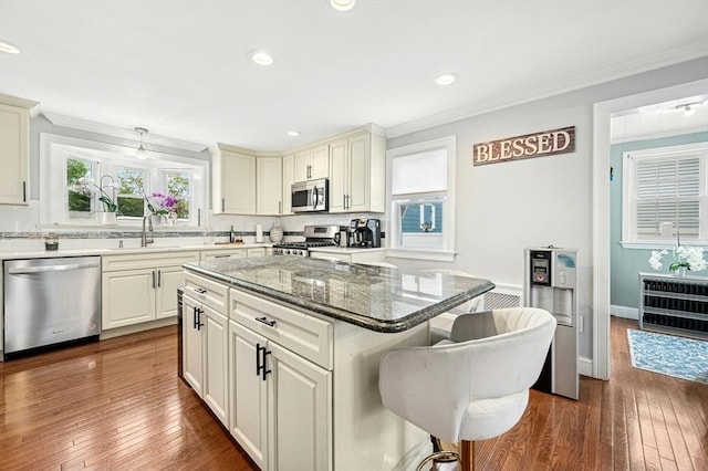 50 Depot St, Milford, MA 01757 - kitchen featuring appliances with stainless steel finishes, a kitchen bar, a sink, dark wood finished floors, and crown molding