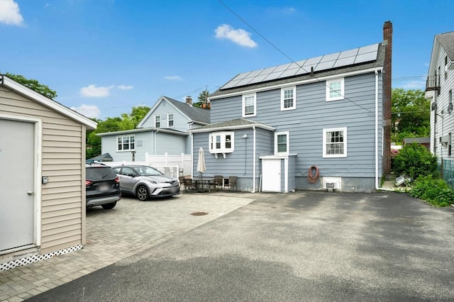 50 Depot St, Milford, MA 01757 - rear view of property featuring solar panels, a chimney, and asphalt driveway