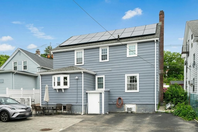 50 Depot St, Milford, MA 01757 - back of house featuring roof mounted solar panels, a patio area, and a chimney