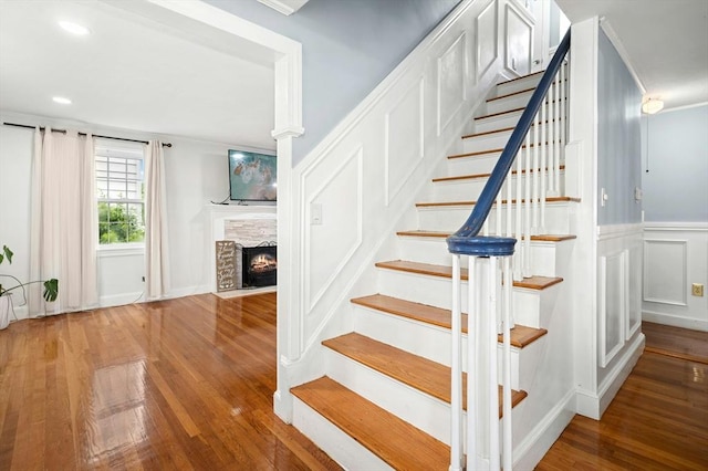50 Depot St, Milford, MA 01757 - stairs featuring wood finished floors, a stone fireplace, ornamental molding, a decorative wall, and a wainscoted wall