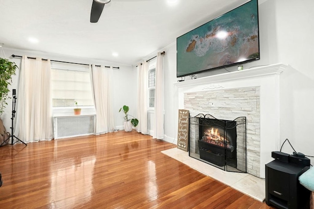 50 Depot St, Milford, MA 01757 - unfurnished living room with radiator, wood finished floors, a fireplace, ceiling fan, and baseboards
