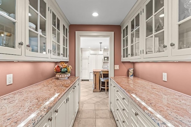 bar area featuring recessed lighting, stainless steel microwave, and light tile patterned floors
