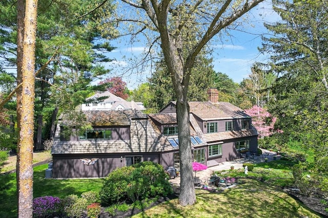 back of house with a patio area, a chimney, and a yard