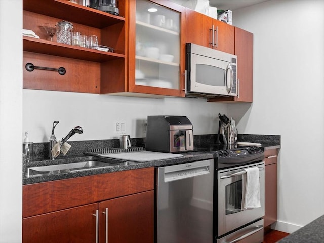 150 Cambridge St Unit 403, Cambridge, MA 02141 - kitchen featuring stainless steel appliances, a sink, glass insert cabinets, brown cabinetry, and dark stone counters