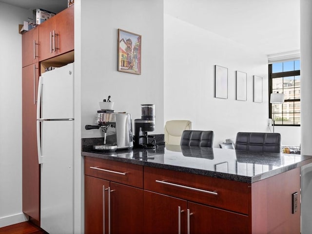 150 Cambridge St Unit 403, Cambridge, MA 02141 - kitchen featuring freestanding refrigerator, a peninsula, and dark stone counters