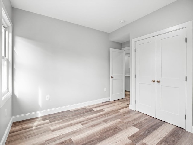 unfurnished bedroom with light hardwood / wood-style floors and a closet