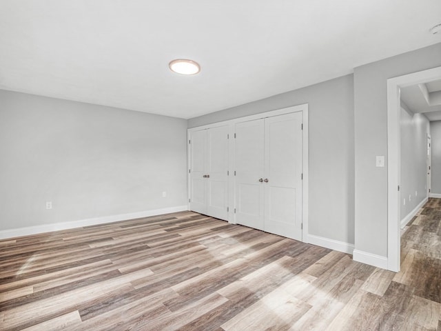 unfurnished bedroom with a closet and light wood-type flooring