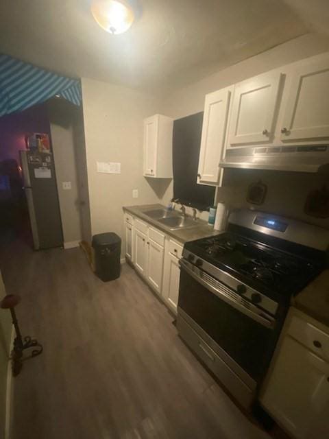 kitchen with sink, stainless steel appliances, white cabinetry, and dark wood-type flooring