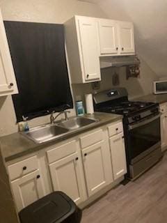 kitchen featuring sink, white cabinets, and gas range