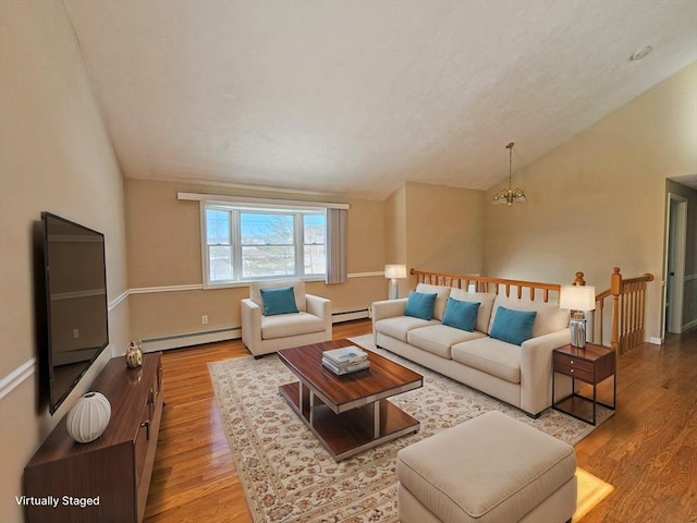 living area with vaulted ceiling, baseboard heating, wood finished floors, and an inviting chandelier