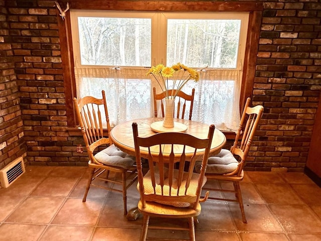 dining room featuring brick wall