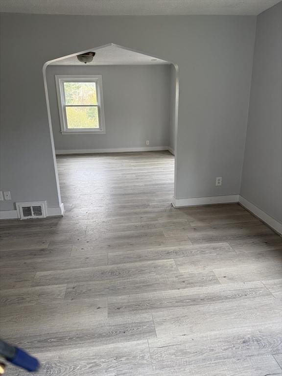 796 Charlton St, Southbridge, MA 01550 - unfurnished room featuring wood finished floors, baseboards, arched walkways, and a textured ceiling