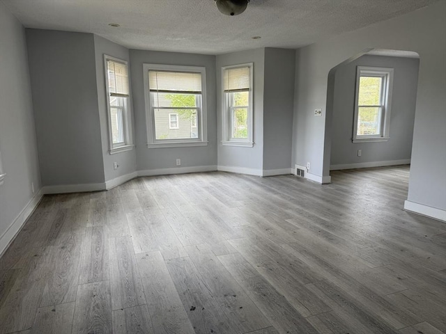 796 Charlton St, Southbridge, MA 01550 - unfurnished room with arched walkways, wood finished floors, a textured ceiling, and baseboards