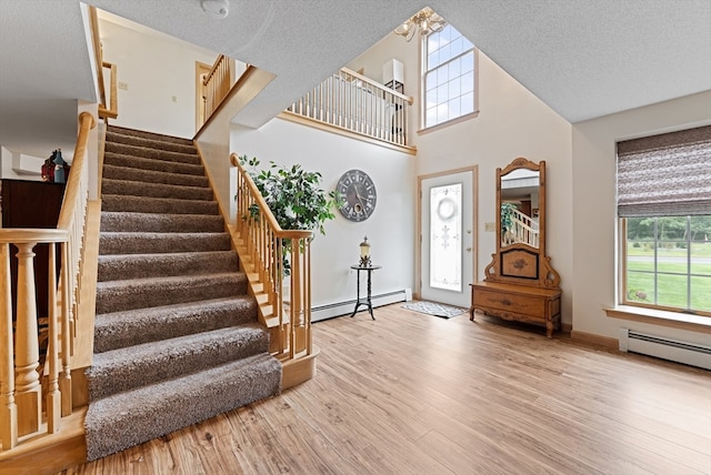 entrance foyer featuring a baseboard radiator, light hardwood / wood-style floors, and a textured ceiling