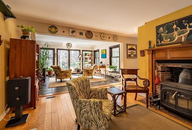 living area featuring light hardwood / wood-style floors and a wood stove