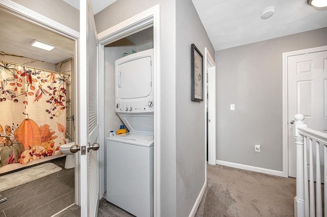 15 Alton St Unit 16, Lowell, MA 01852 - washroom featuring stacked washer and clothes dryer, baseboards, and carpet