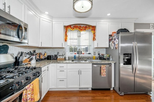 15 Alton St Unit 16, Lowell, MA 01852 - kitchen with appliances with stainless steel finishes, a sink, white cabinetry, wood finished floors, and light stone counters
