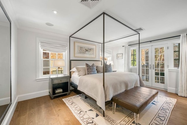 bedroom featuring ornamental molding, hardwood / wood-style floors, and french doors