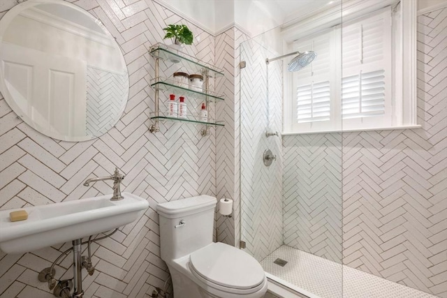 bathroom with crown molding, a tile shower, and toilet