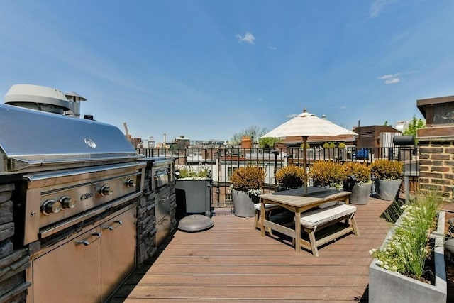 wooden terrace featuring a grill and exterior kitchen