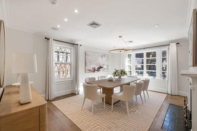 dining space with ornamental molding, a notable chandelier, and dark hardwood / wood-style flooring