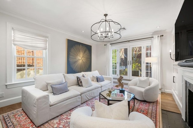 living room with an inviting chandelier, crown molding, and dark hardwood / wood-style floors