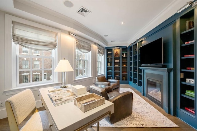 sitting room with ornamental molding and wood-type flooring