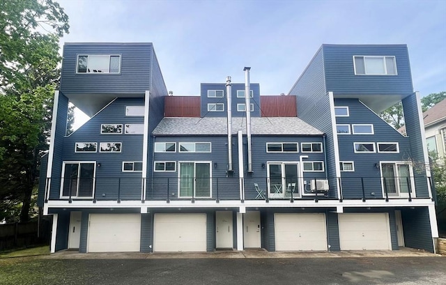 back of property featuring a garage and a balcony