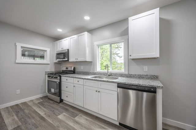 338-340 Main St, Fairhaven, MA 02719 - kitchen featuring stainless steel appliances, light wood-type flooring, white cabinetry, light stone countertops, and recessed lighting