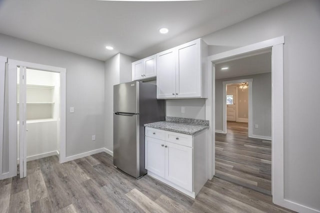338-340 Main St, Fairhaven, MA 02719 - kitchen featuring freestanding refrigerator, light wood-type flooring, white cabinets, light stone counters, and recessed lighting
