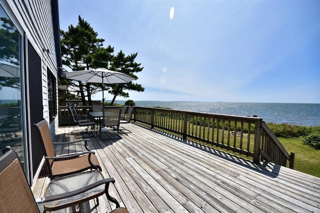 wooden deck featuring outdoor dining space and a water view