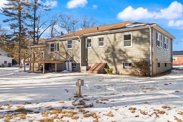 snow covered house with a wooden deck