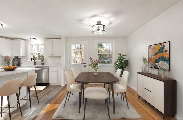 dining area with sink and light hardwood / wood-style flooring