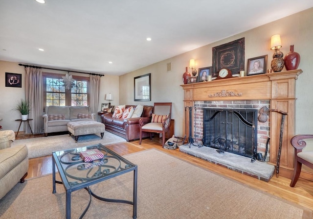 living room with hardwood / wood-style flooring and a brick fireplace