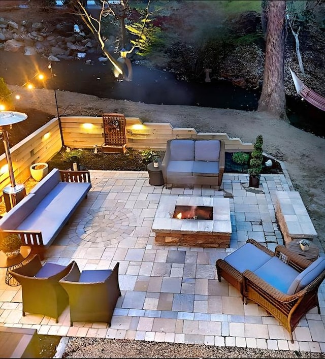 view of patio with an outdoor living space with a fire pit