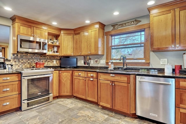 kitchen featuring appliances with stainless steel finishes, sink, and dark stone countertops