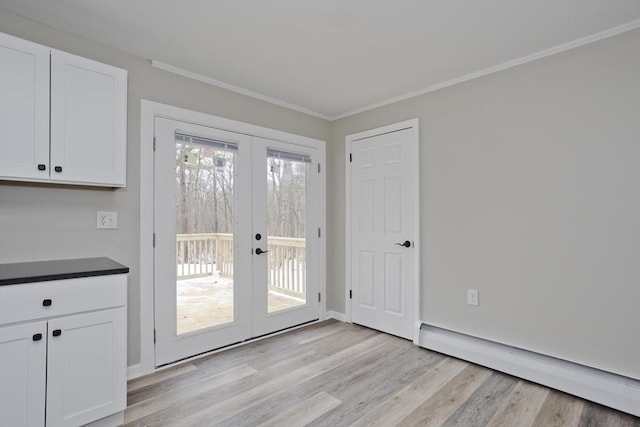 entryway featuring a baseboard radiator, ornamental molding, light hardwood / wood-style floors, and french doors