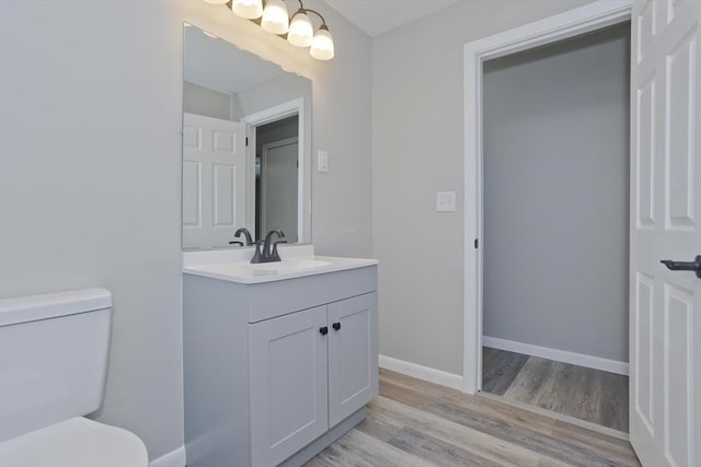 bathroom with wood-type flooring, toilet, and vanity