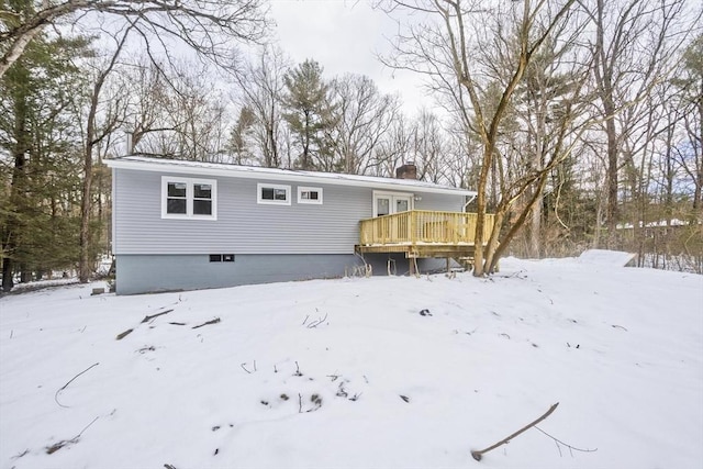 snow covered property with a deck