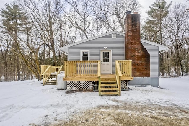 snow covered rear of property featuring a deck